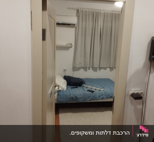 דלת פתוחה לחדר עם מיטה ווילון